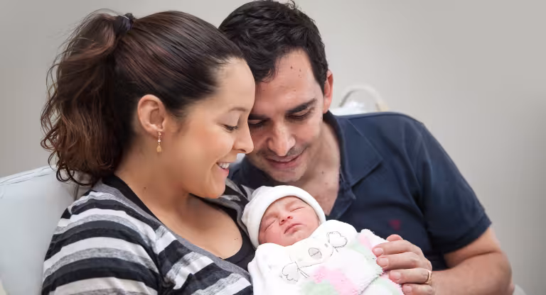 newborn baby held by parents