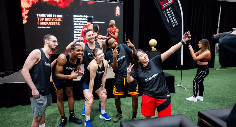 Group of people in sports attire taking a selfie at an indoor event