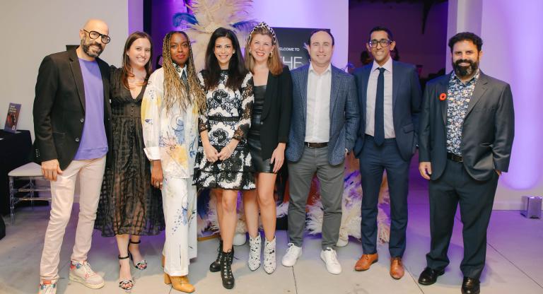 Group photo of young professionals at a party wearing business casual outfits