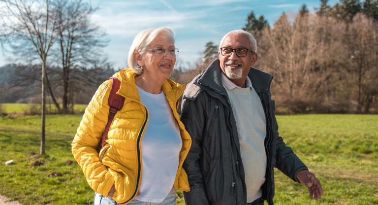 Older man and woman walking outdoors in a park