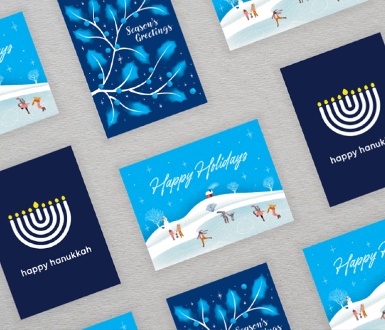 Assorted Sinai Health holiday and Hanukkah cards arranged on a grey background.