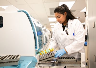 Lab technologist loading samples into automated analyzer.