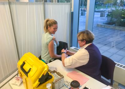 nurse administering a flu vaccine to employee