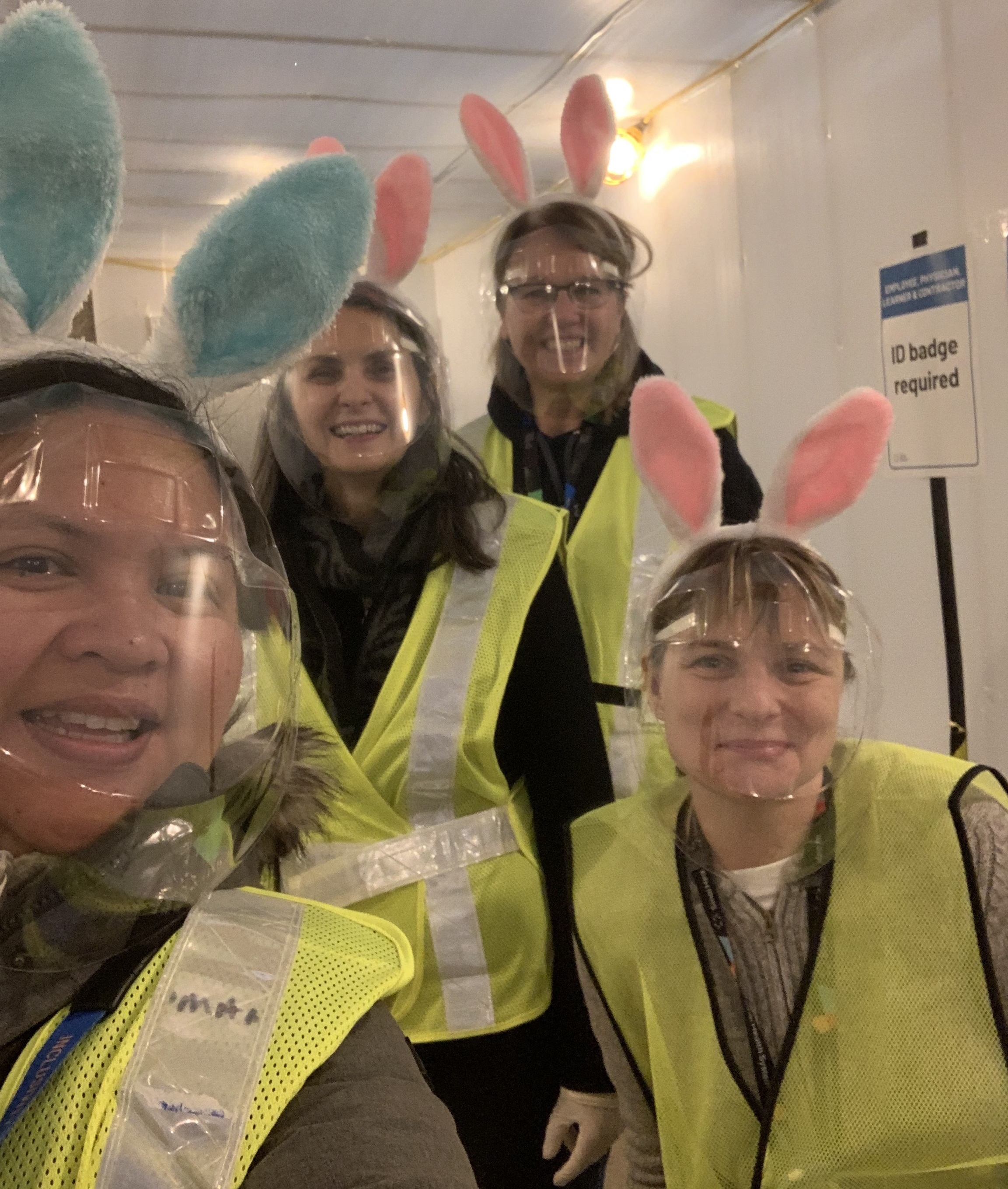 Hospital employees wearing reflective vests and face shields with easter bunny ears