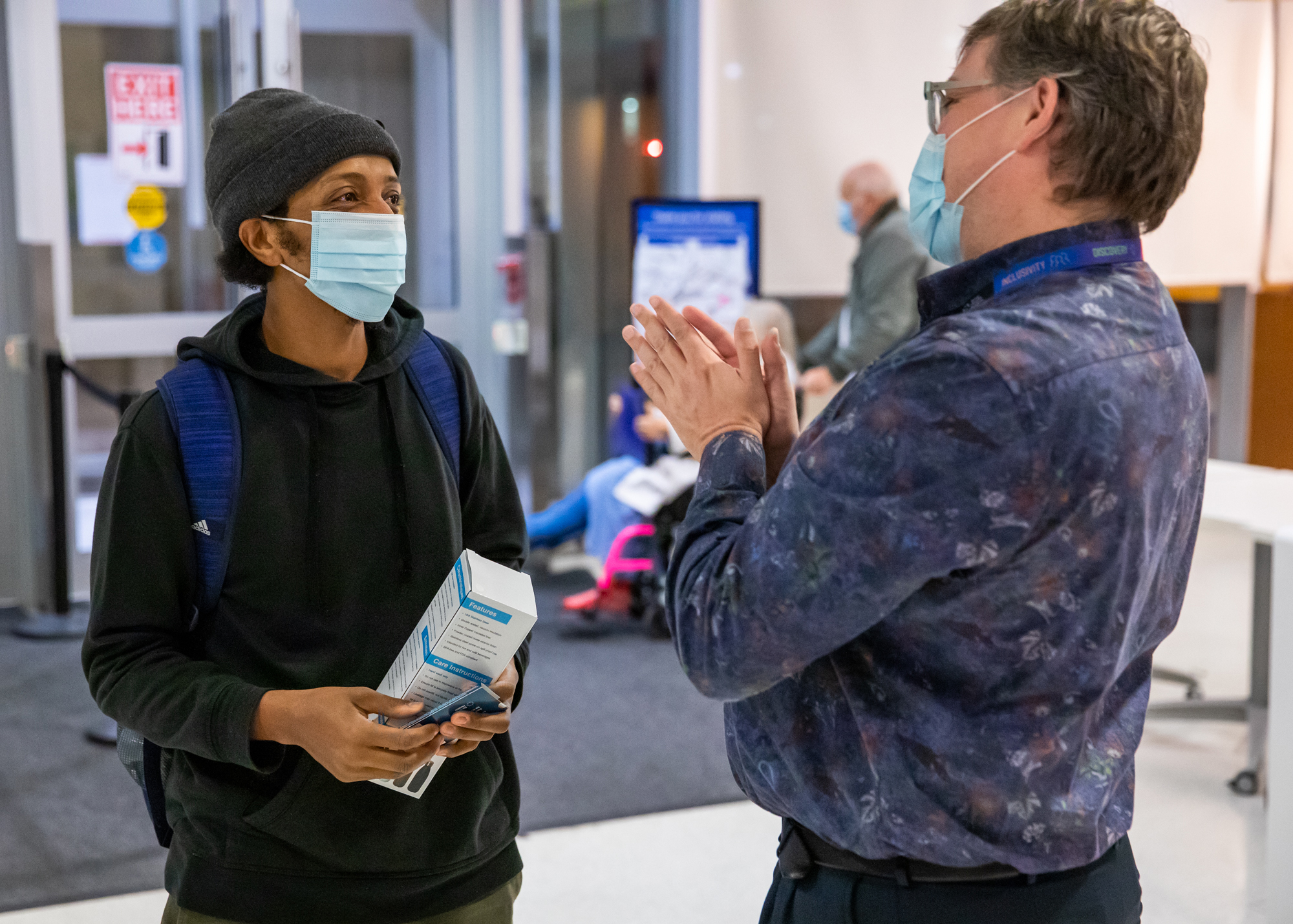 Dr. Mark Lachman a leader at Bridgepoint Hennick Hospital, makes a thank you gesture with his hands as he speaks with an employee arriving at the hospital.