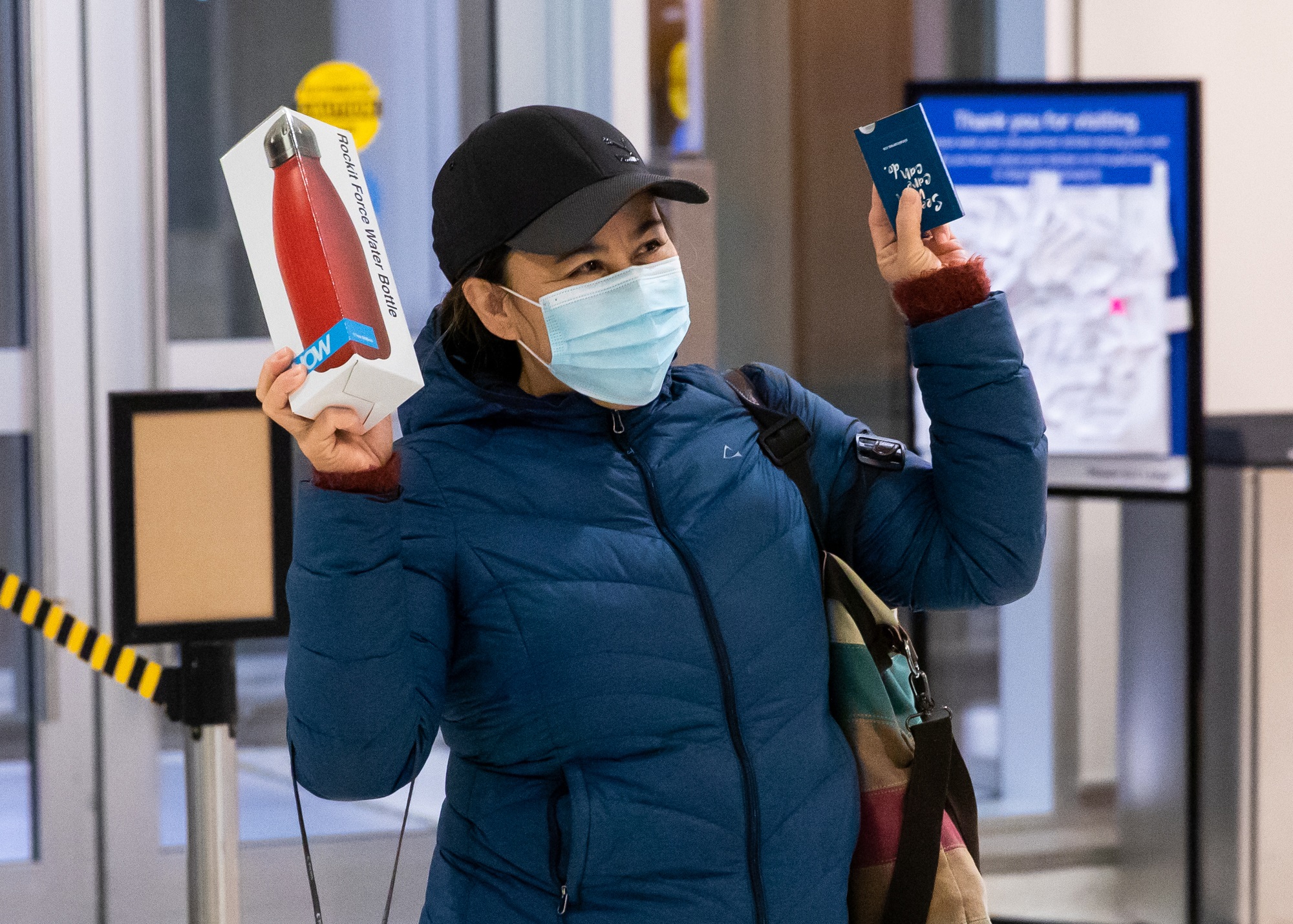 An employee at Hennick Bridgepoint Hospital with her arms up holding a water bottle as she is arriving at the hospital.